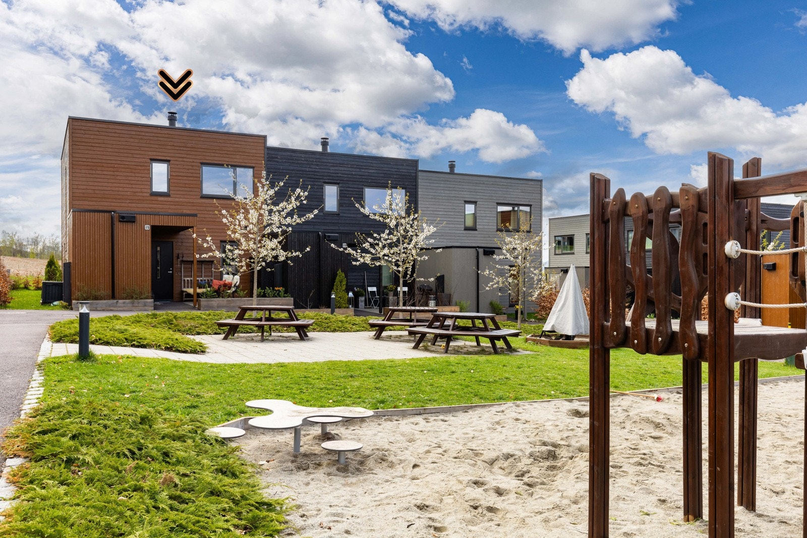 Utenfor boligen er det lekeplass og sitteplasser i et hyggelig nabolag. Galleribilde