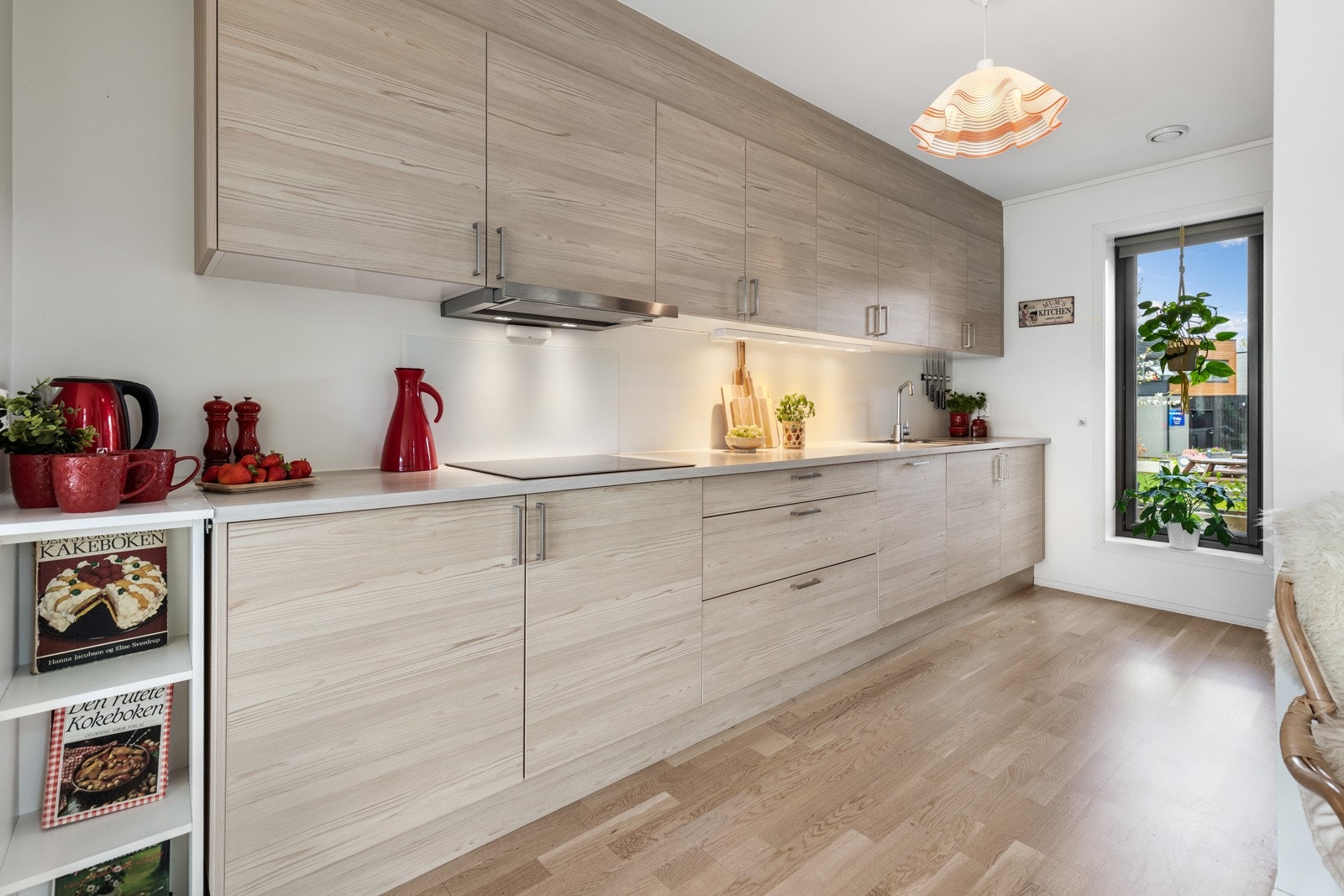 Romslig kjøkken med lyse fronter, integrerte hvitevarer og godt med oppbevaringsplass. Store vinduer som gir naturlig lysinnslipp. Galleribilde