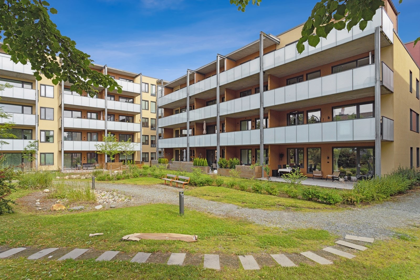 Bygget som leiligheten ligger i er litt tilbaketrukket fra veien og har et fint grøntområde i forkant. Galleribilde