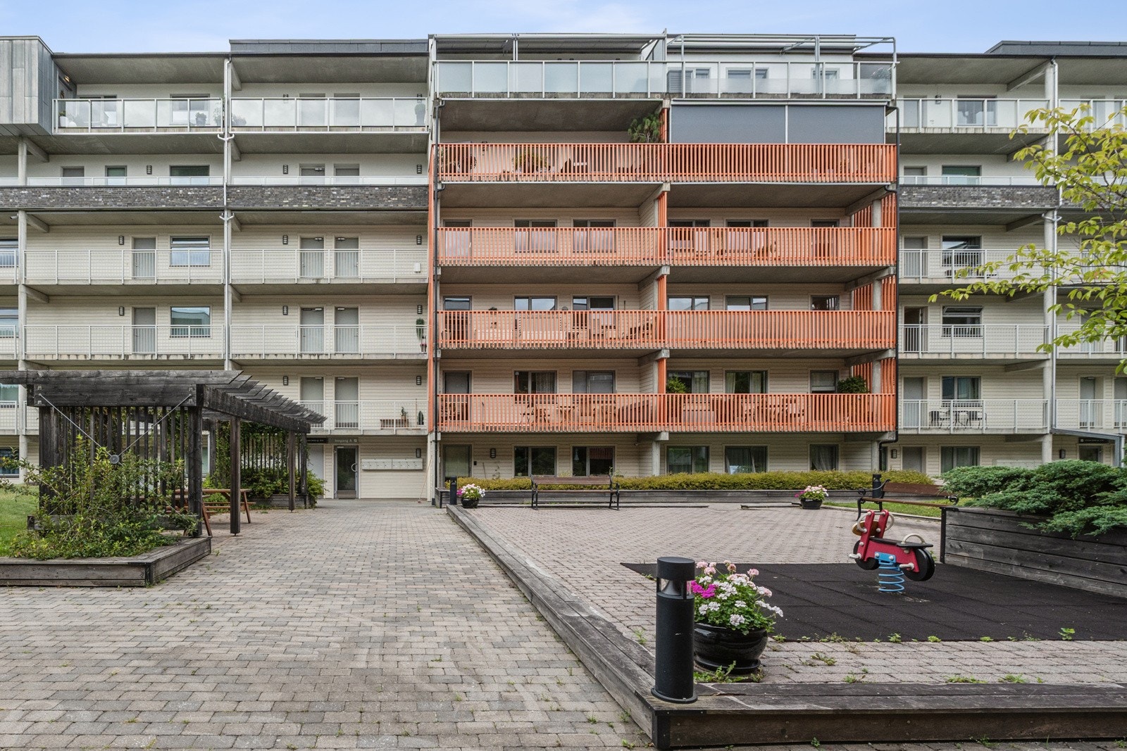 Inngangsparti med godt vedlikeholdt uteområde og sittegrupper. Galleribilde