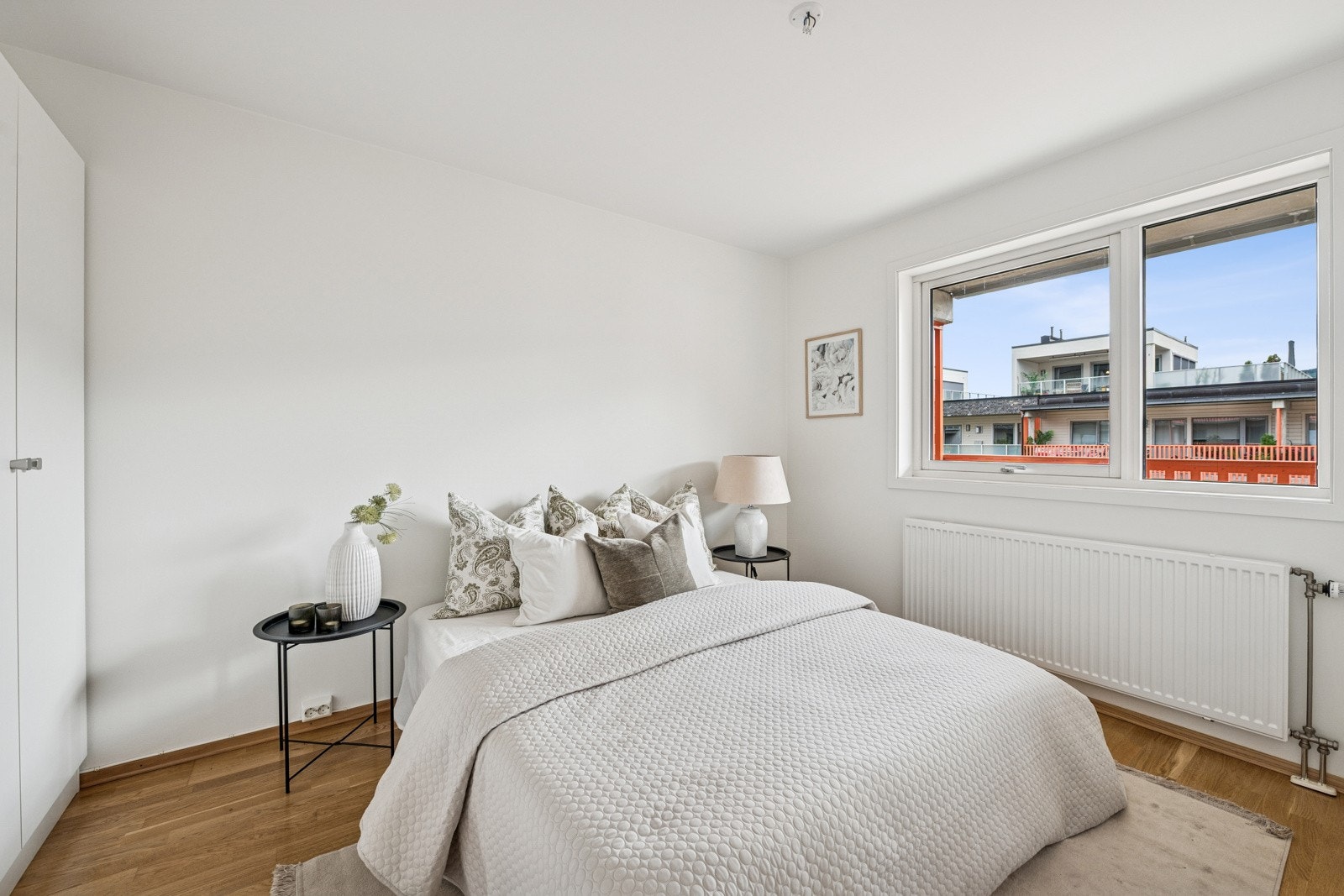 Soverom med lysmalte vegger og stort vindu som gir godt med naturlig lys. Galleribilde