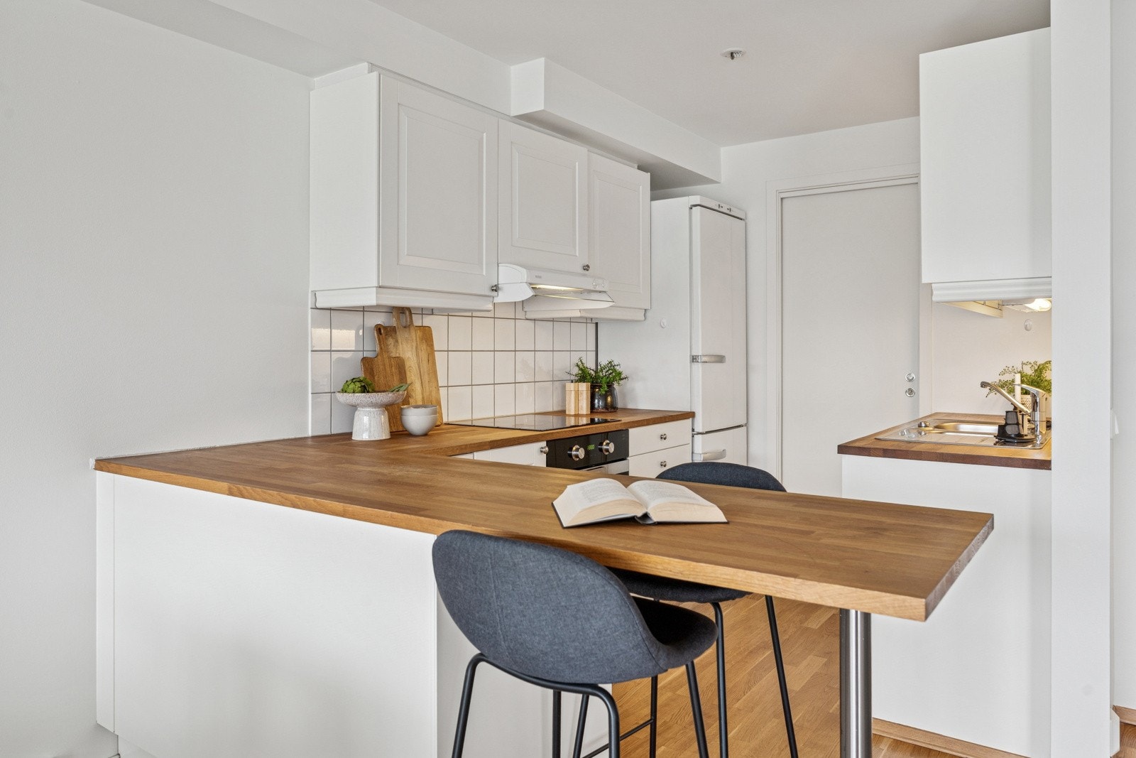 Smart barløsning som skiller kjøkkenet fra spisestuen, samtidig som den gir ekstra benkeplass og en sosial sone . Galleribilde