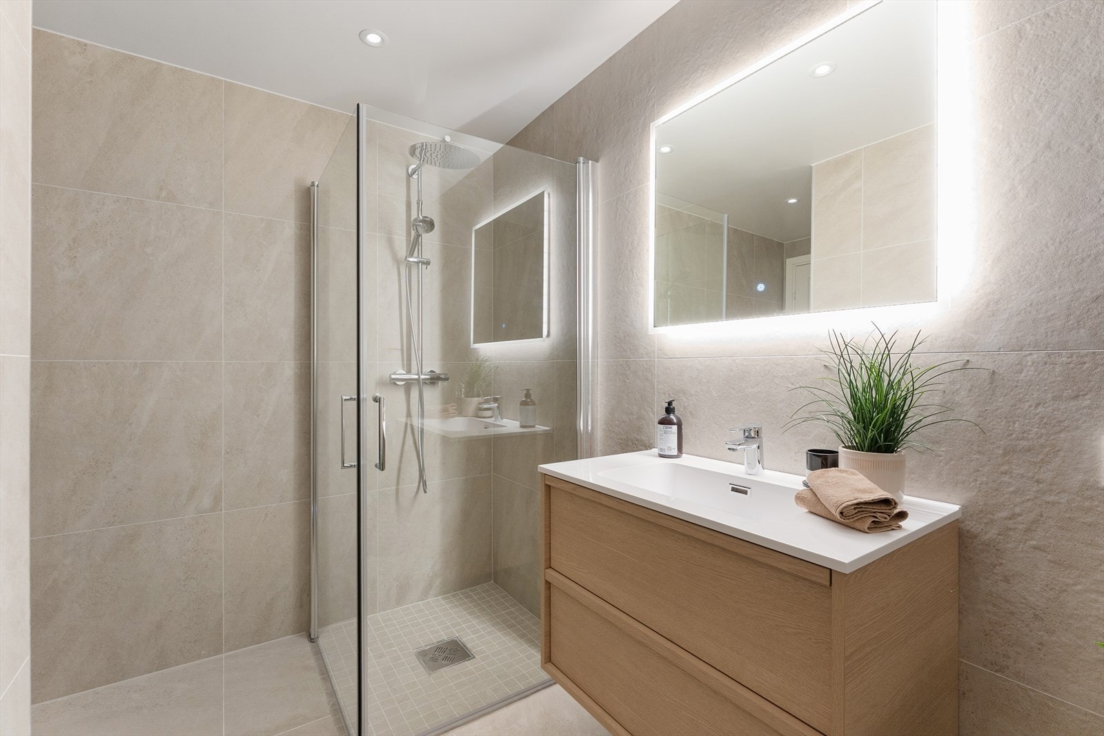 Badet består av flislagt gulv med varmekabler, flislagte vegger og malt himling. Galleribilde