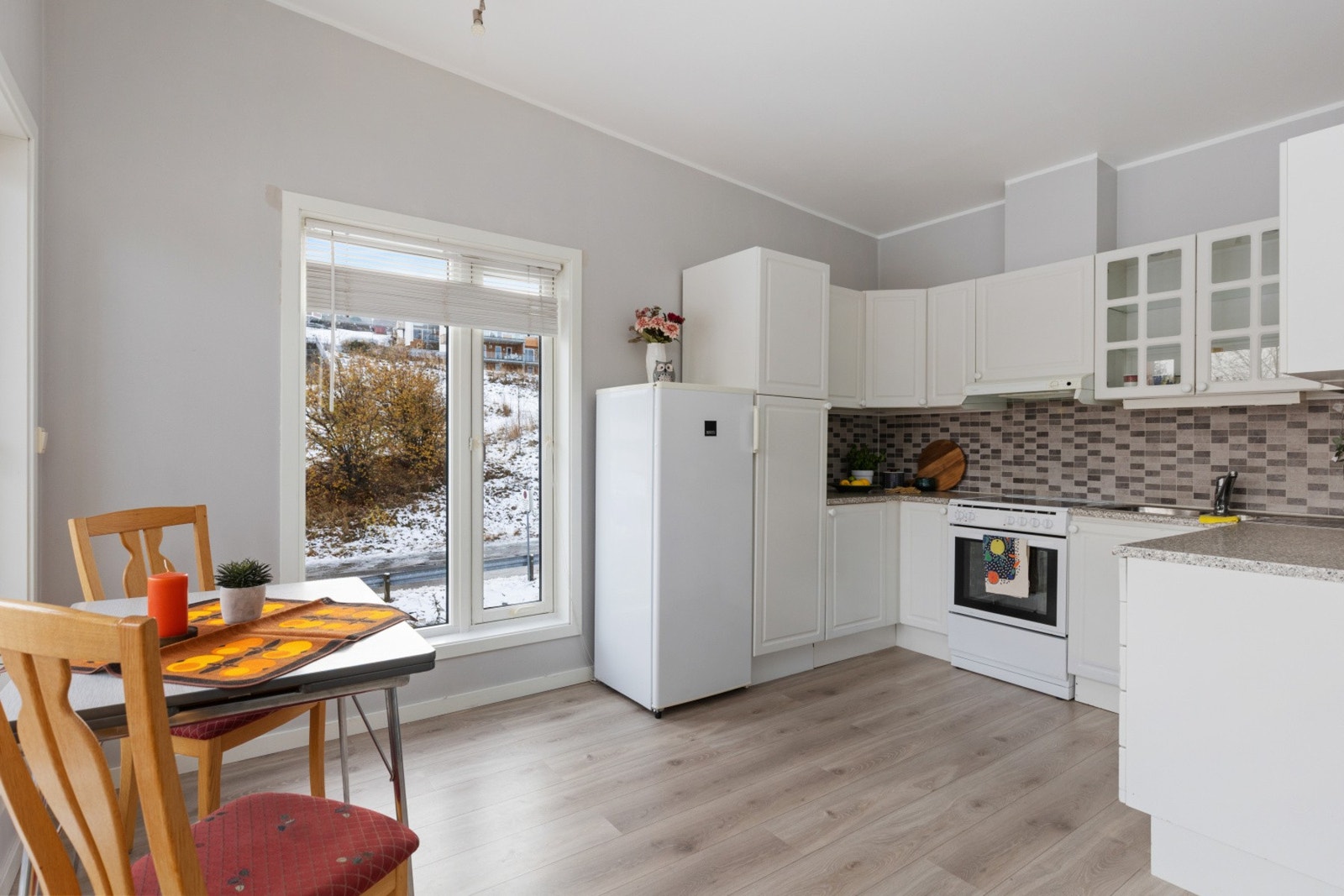 Laminat på gulv, malte overflater på vegger med flis over benkeplate. Galleribilde