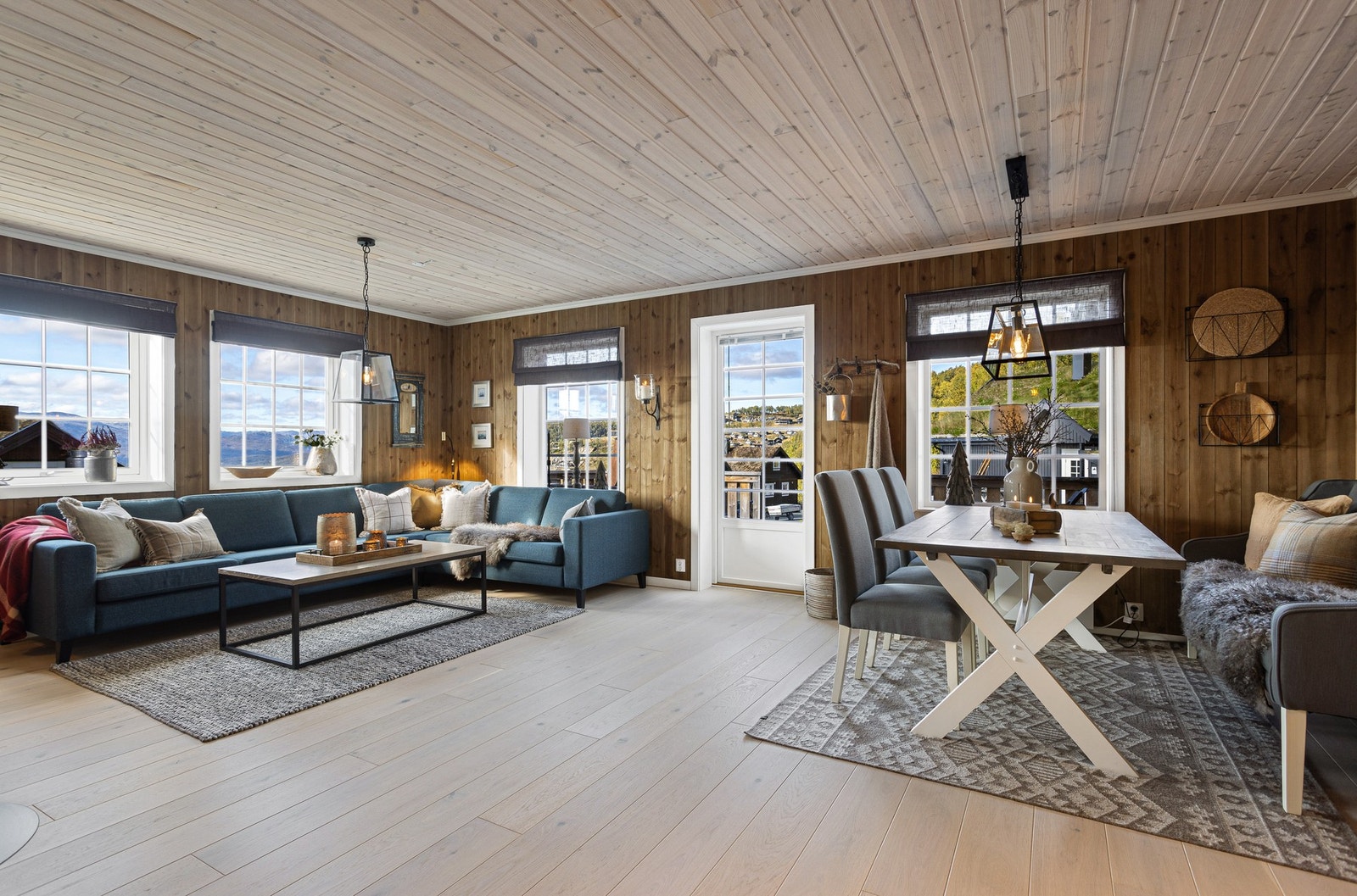 Rommet har mye vinduer som slipper inn naturlig lys og bringer utsikten inn i sofakroken Galleribilde