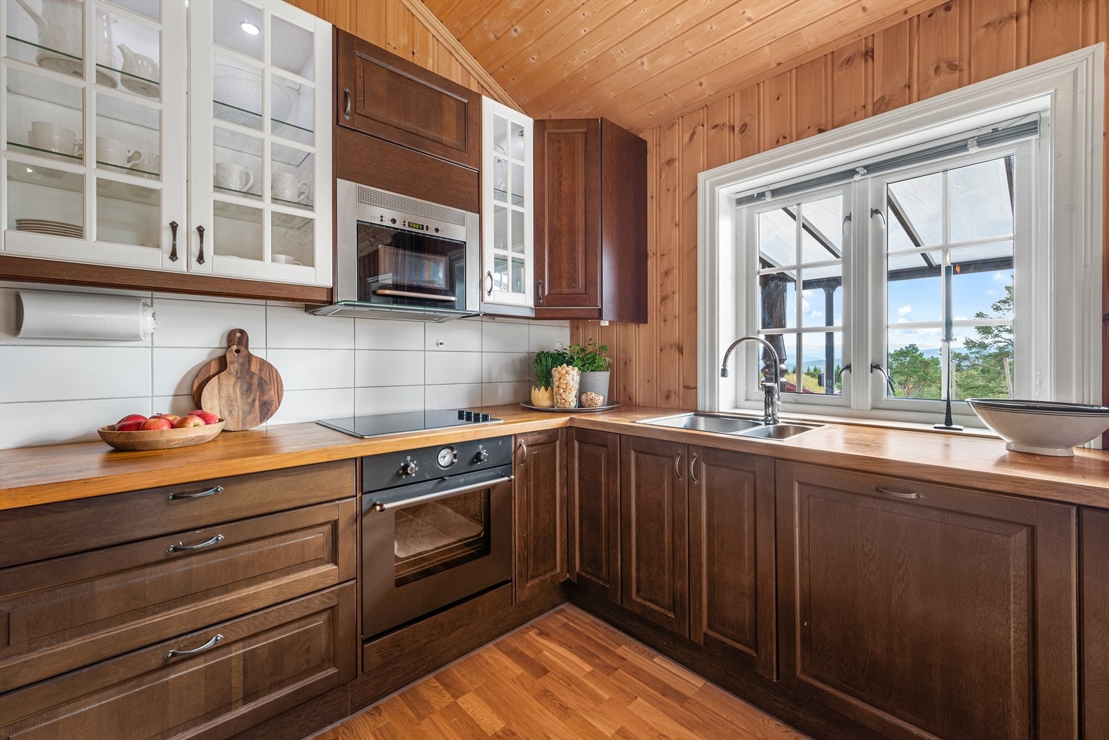 Kjøkkenet ligger i åpen løsning mot stuen med mørkebrun innredning i et klassisk design. Galleribilde