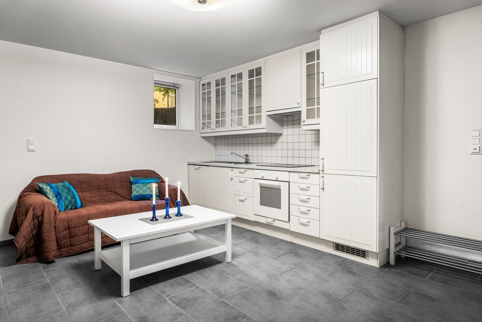 Rommet har kjøkkenløsning. Kjøkkenet har lys laminat benkeplate med nedfelt stålkum, samt integrerte hvitevarer fra Ikea som oppvaskmaskin, kjøl/frys, stekeovn og platetopp samt avtrekksvifte i overskap Galleribilde