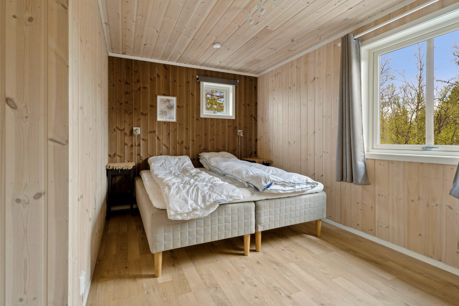 Soverom i første etasje med trepanel på veggene som gir et varmt preg. Galleribilde