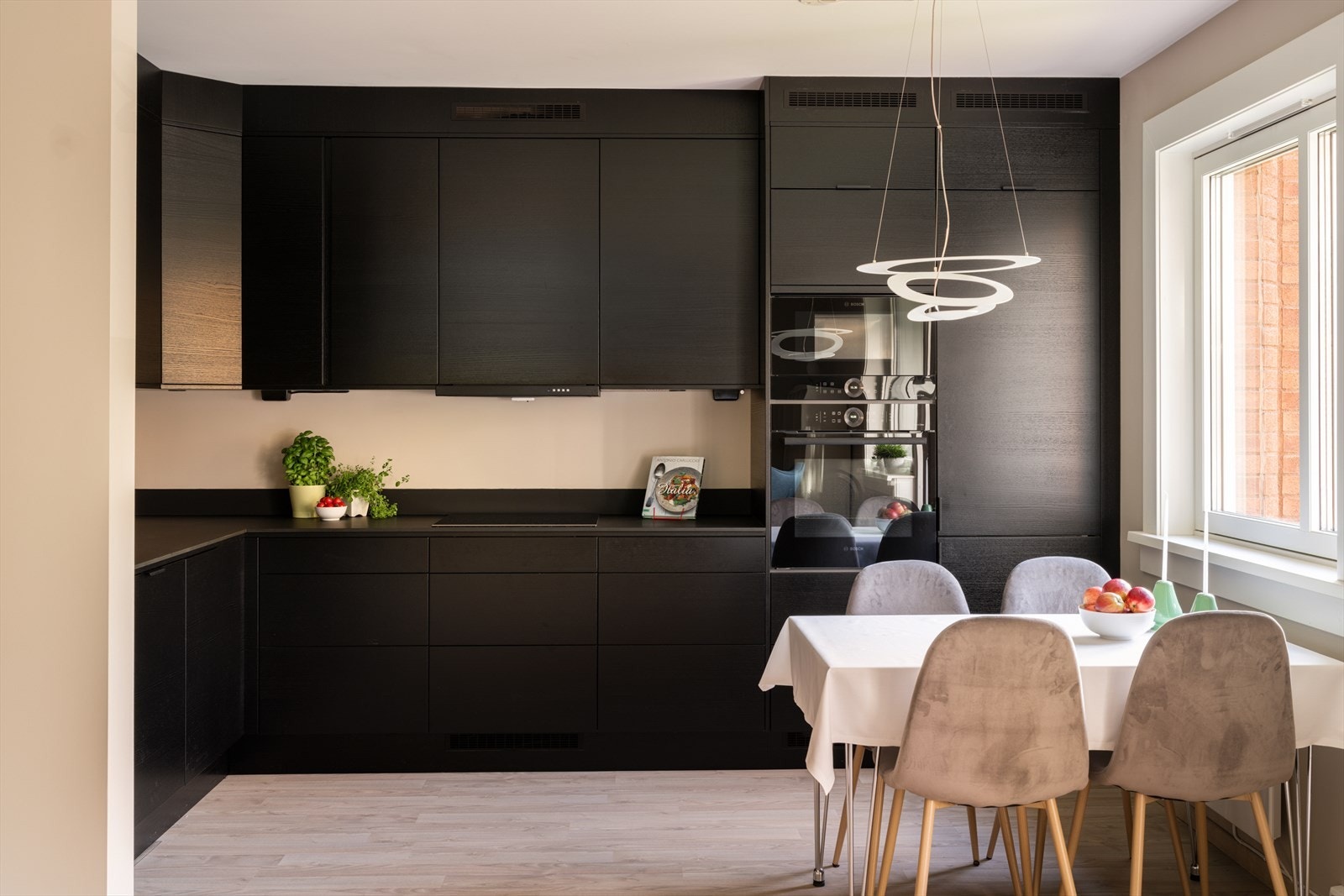 Kjøkkenet fra 2023 har en stilren innredning med glatte, mørke fronter og rikelig med skapplass. Galleribilde