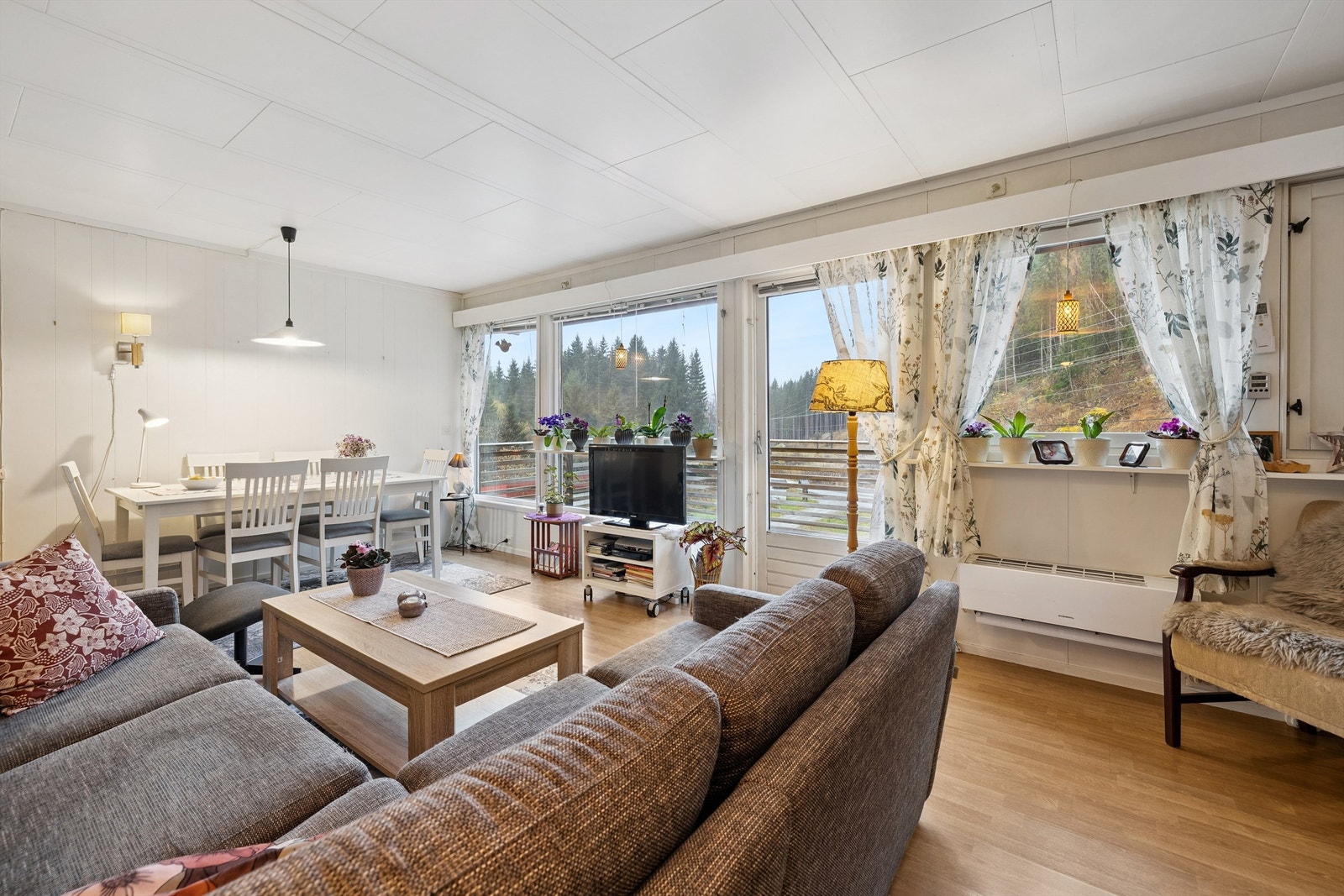 Stuen har plass til både sittegruppe og spisebord, med store vindusflater mot det vakre landskapet rundt eiendommen Galleribilde