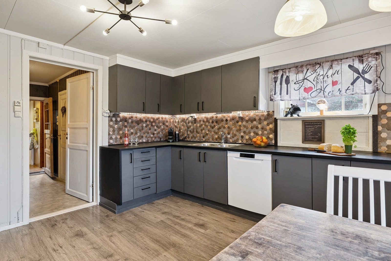 Innredningen har glatte fronter og laminert benkeplate, med plass til frittstående hvitevarer. Galleribilde