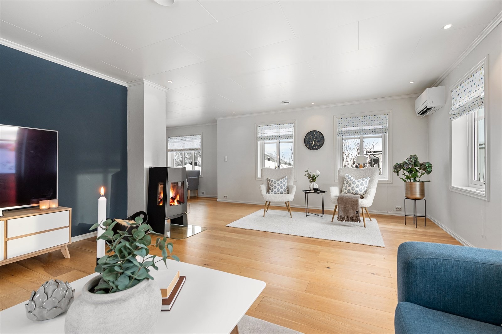 Romslig stue med vedovn og varmepumpe. Tilkomst videre til stor terrasse med god plass til ønsket møblering. Galleribilde