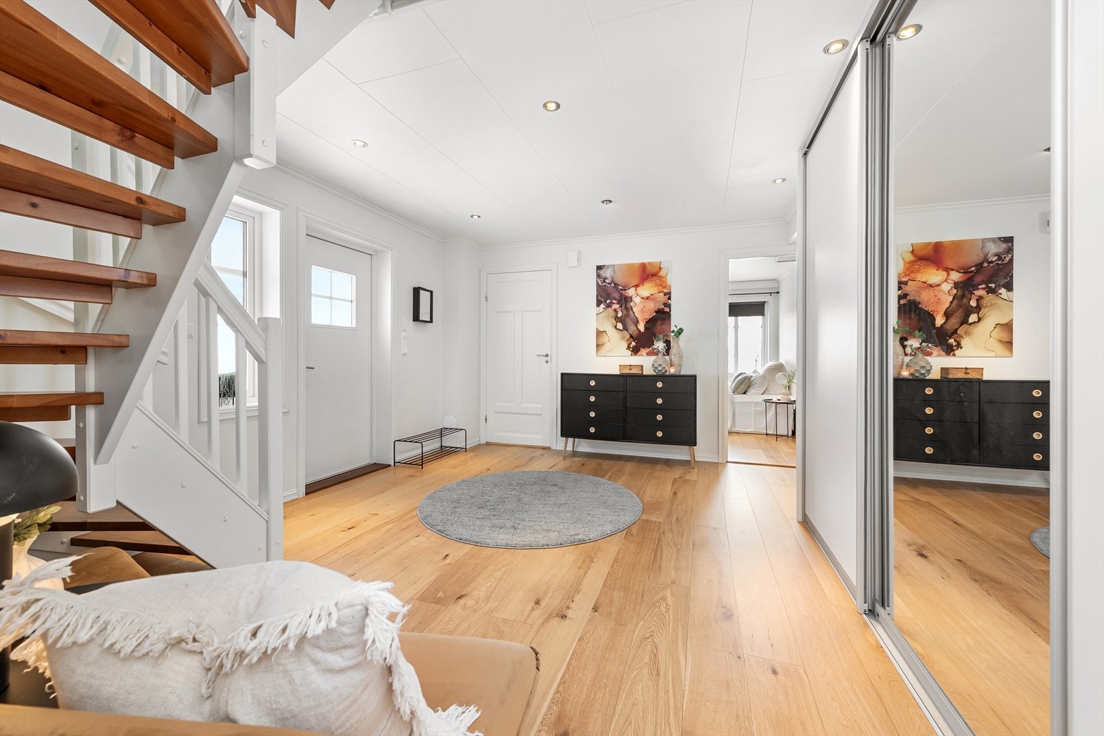 Romslig og innbydende hall med stor skyvedørsgarderobe. Galleribilde