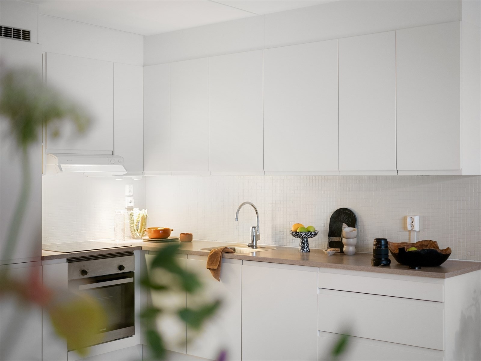 Det er komfyrvakt og kjøkkenvifte med felles mekanisk avtrekk. Galleribilde