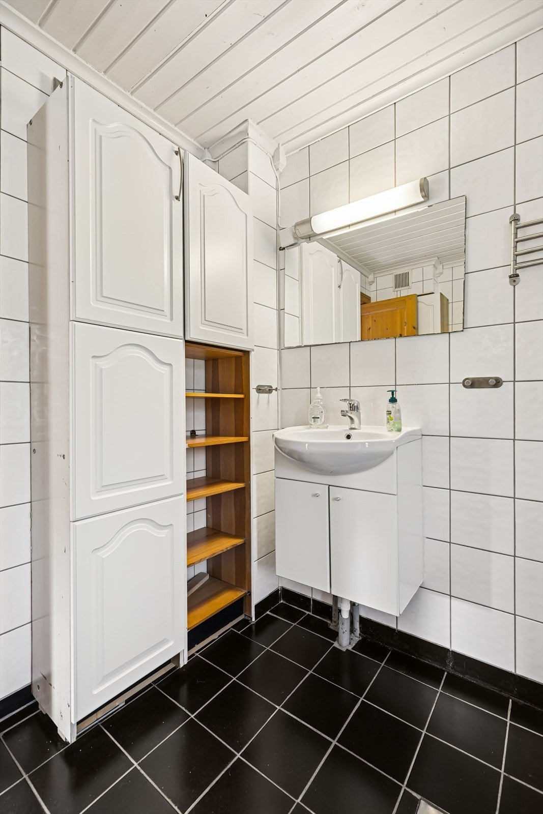 Rommet er utstyrt med innredning med nedfelt servant, toalett og dusjkabinett. Det er mekanisk avtrekk. Badet har plastsluk og synlig membran/belegg i sluk. Galleribilde