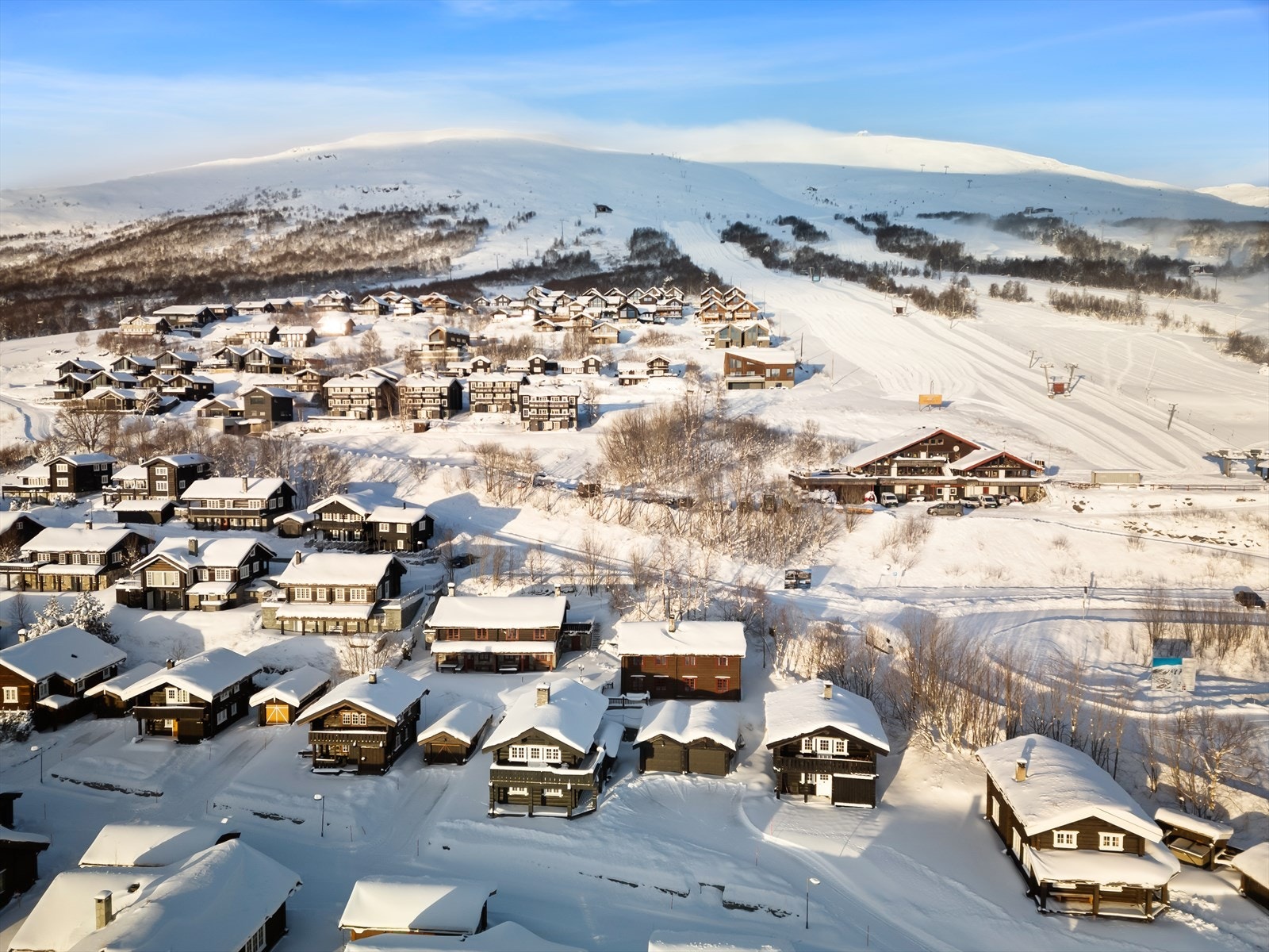 Her kan du starte dagen med kaffe på terrassen mens sola stiger over fjellene, og avslutte med peiskos etter en dag i bakken - alt uten å måtte bruke bilen. Galleribilde