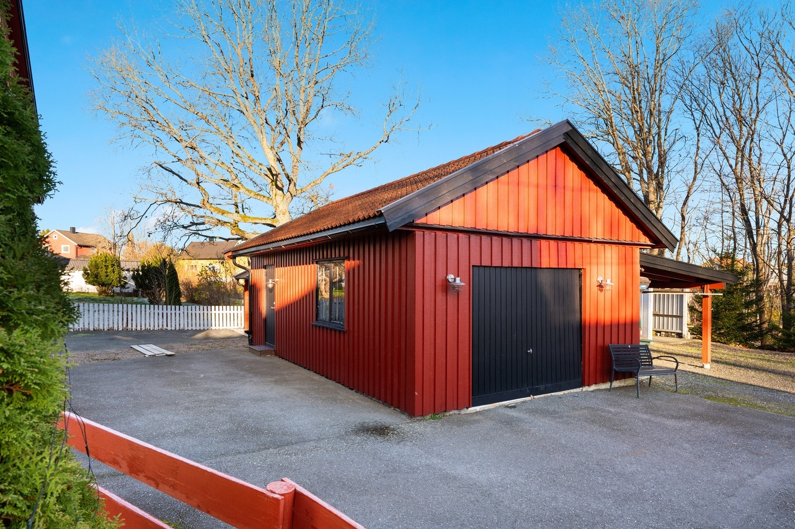 Rødmalte yttervegger og asfaltdekke gir en solid garasjeløsning med enkel tilgang. Galleribilde