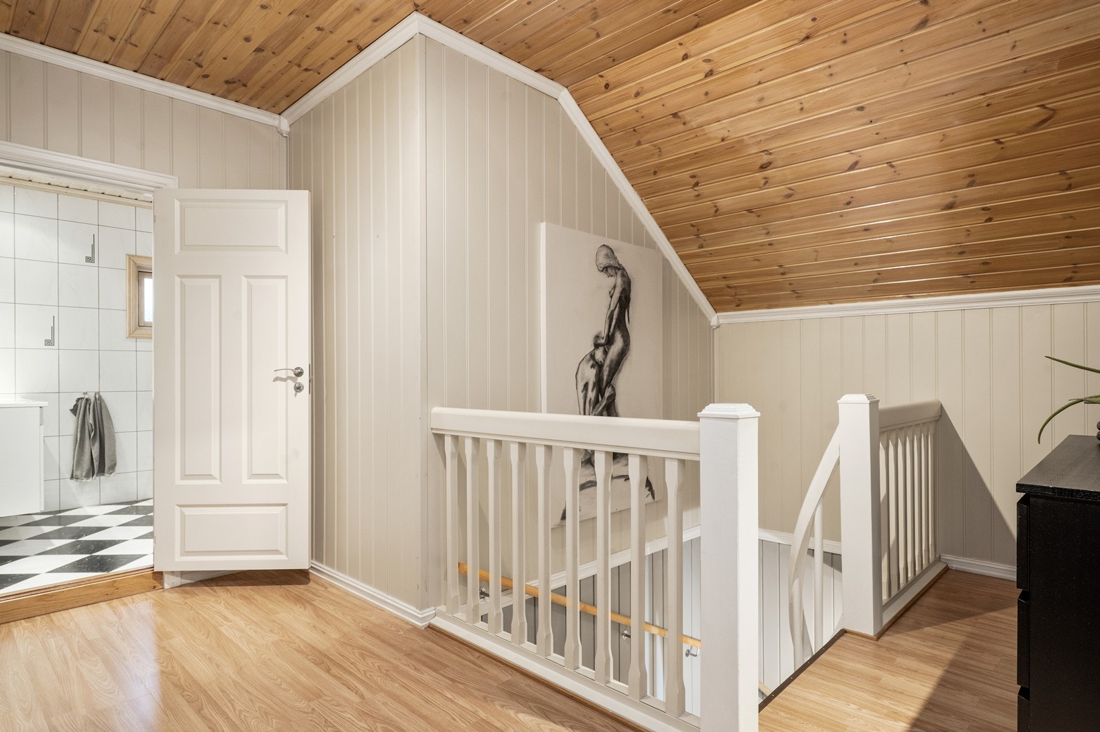 Trappen gir direkte tilgang til andre etasje med panelte vegger og tak. Laminatgulv gir en slitesterk overflate i gangen. Galleribilde