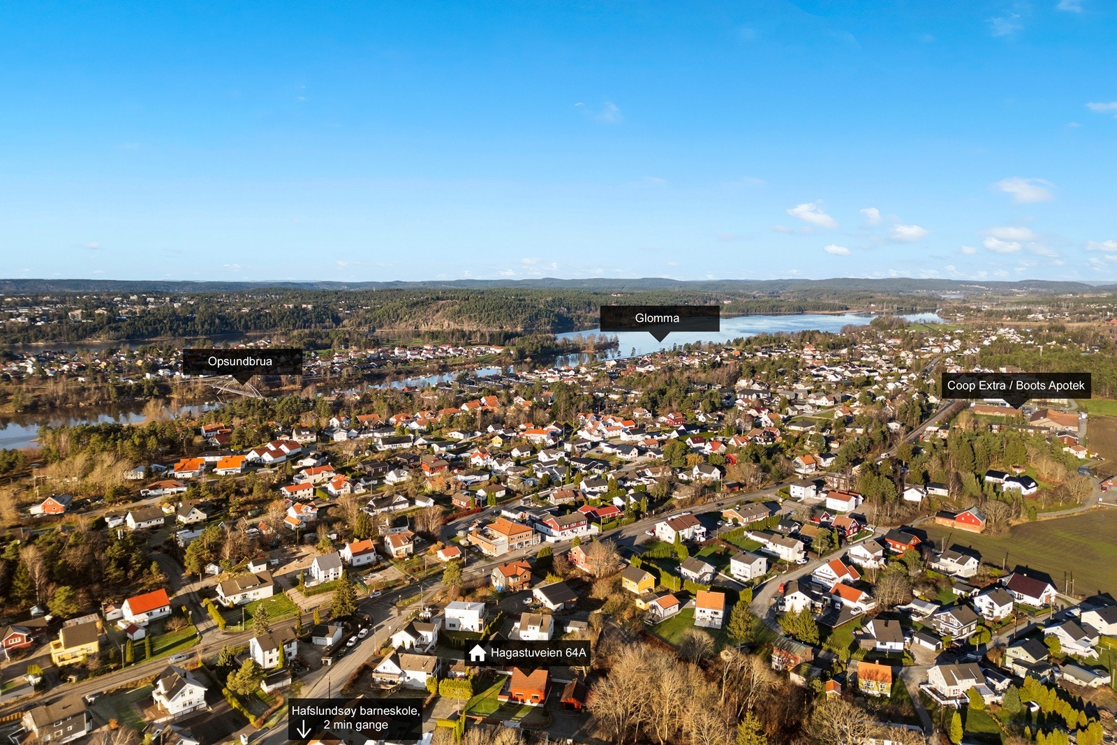 Luftfotoet viser beliggenheten i forhold til Glomma og nærliggende fasiliteter som skole og butikker. Galleribilde