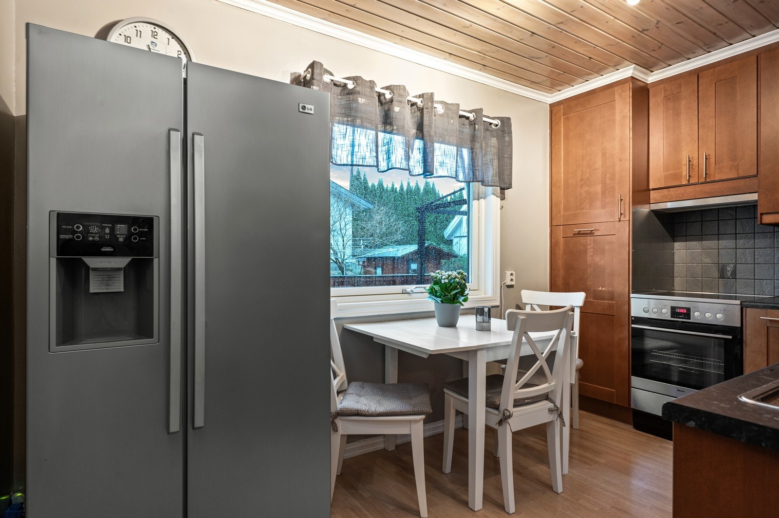 Plassering av spisebordet ved vinduet gir naturlig lysinnslipp til kjøkkenområdet. Galleribilde