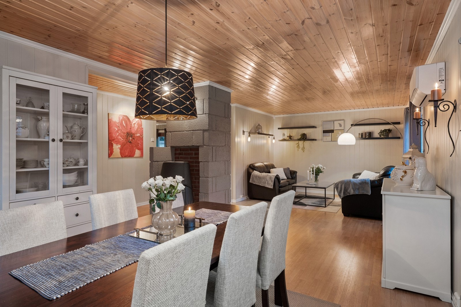 Panelte vegger og tak gir en varm og innbydende stueopplevelse. Vedovn i hjørnet sørger for effektiv oppvarming av rommet. Galleribilde