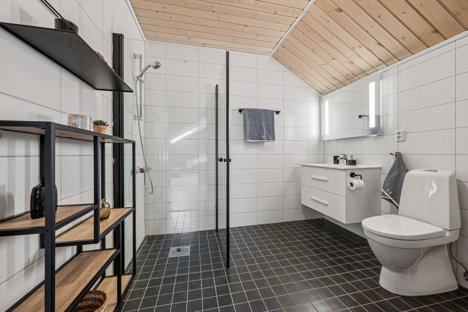 Det andre badet er innredet med heldekkende servant, speil med belysning og dusj med innfellbare dusjdører. Adkomst til bod i knevegg. Galleribilde