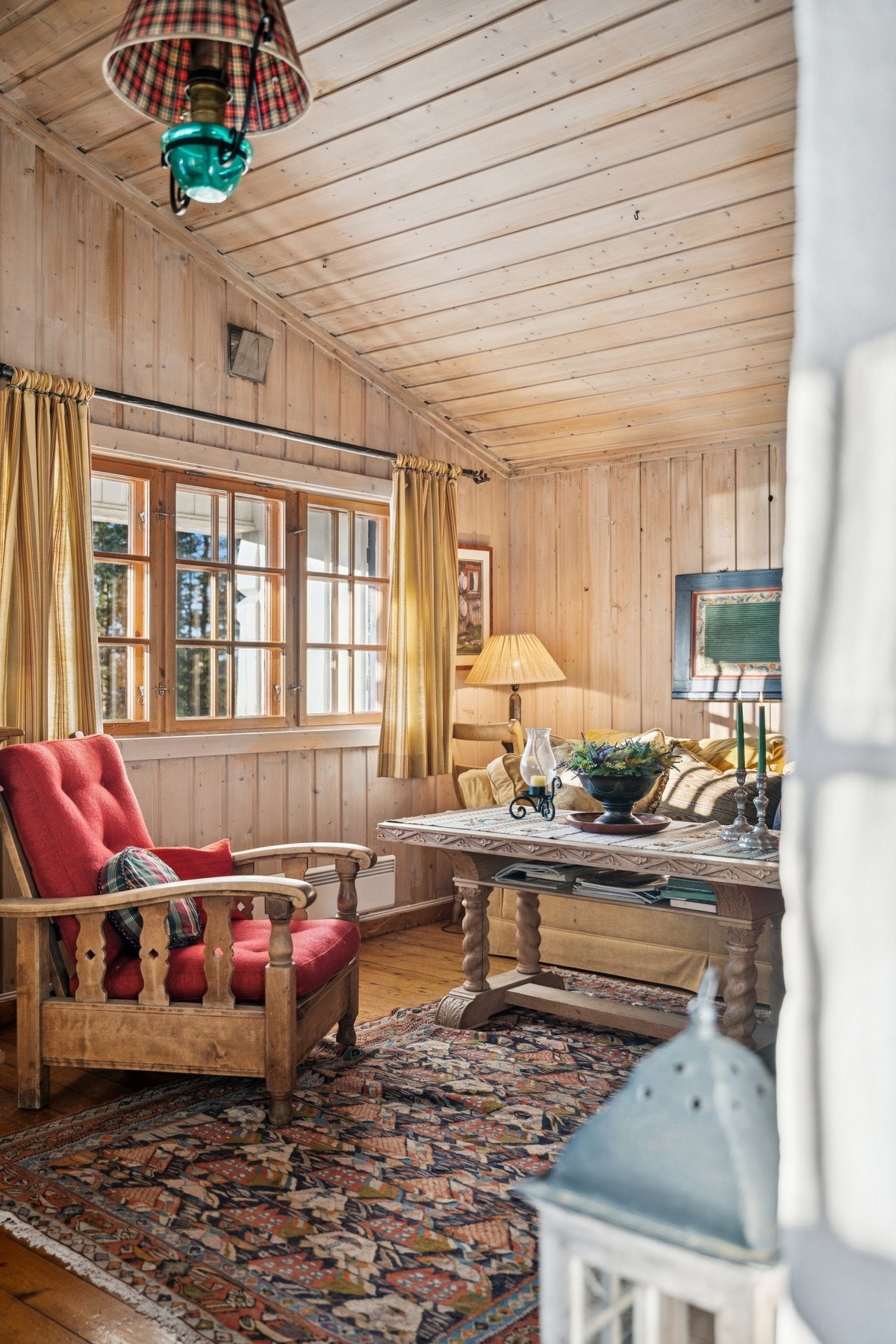 Stuen byr på varme materialer og et vakkert utsyn mot terrenget. Galleribilde