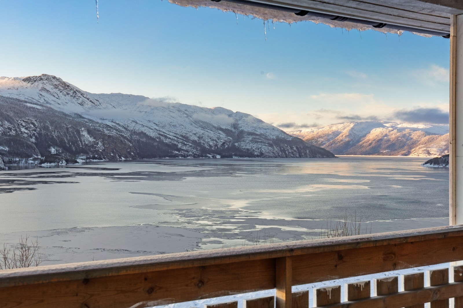 Fantastisk utsikt over fjorden og snødekte fjell. Galleribilde