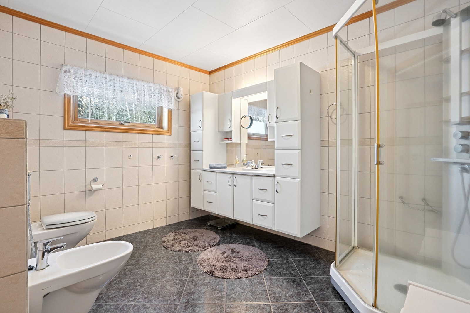 Romslig baderom med dusjkabinett, god oppbevaringsplass og praktisk innredning Galleribilde