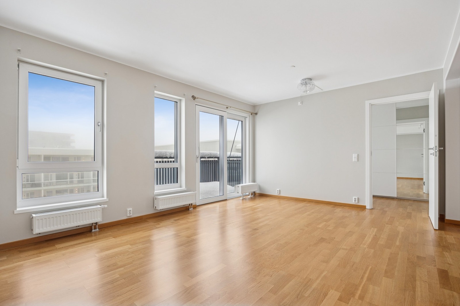 Store vindusflater slipper inn rikelig med naturlig lys og bidrar til en lys og luftig atmosfære i oppholdsrommet. Galleribilde