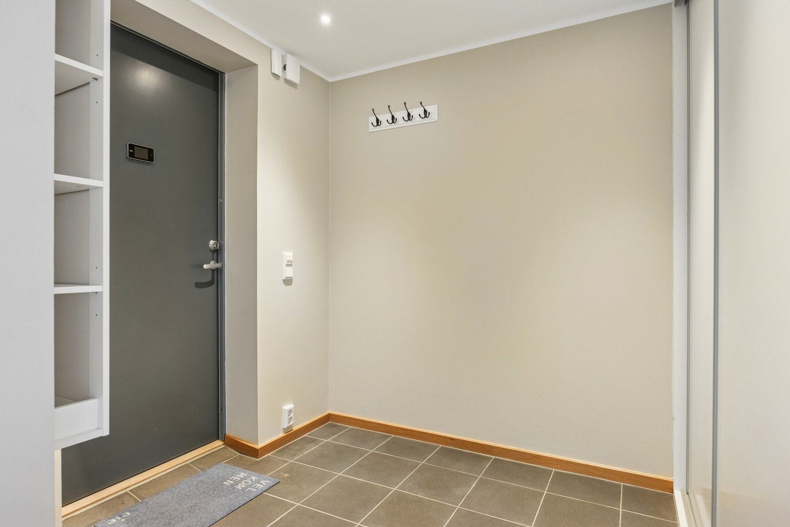 Innbydende og funksjonell entré med flislagt gulv som gir et moderne uttrykk og enkel rengjøring. Galleribilde