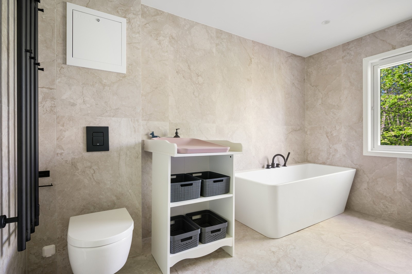 Det er innredet med dobbel servant, vegghengt toalett, dusj med rennesluk og frittstående badekar Galleribilde