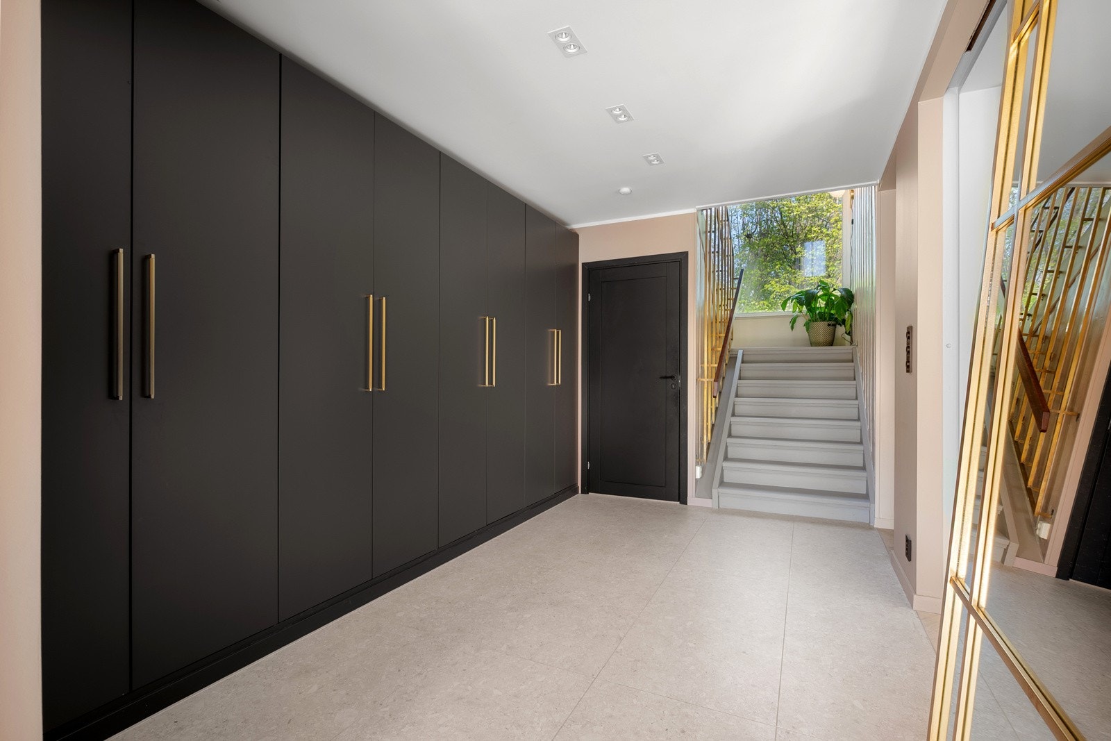 Romslig entré med stort, plassbygget garderobeskap som gir rikelig med oppbevaringsplass Galleribilde