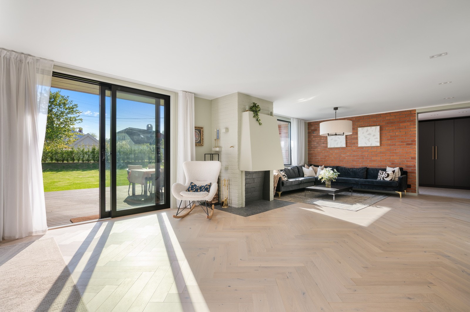 Et romslig og gjennomgående rom med store vindusflater som gir rikelig med lysinnslipp og flott utsyn mot hagen Galleribilde