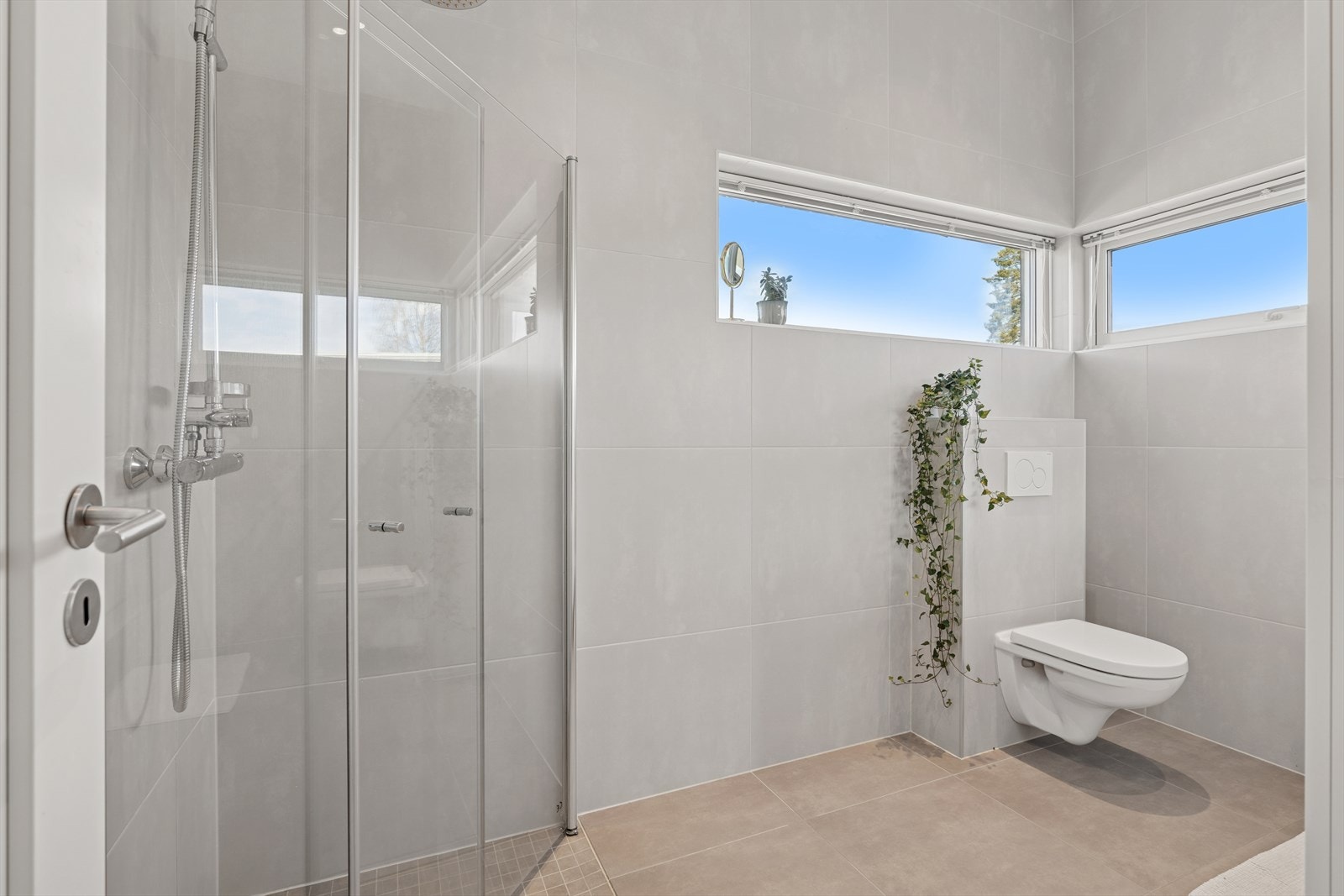 Badet er moderne og funksjonelt, med fliser på vegger og gulv. Galleribilde