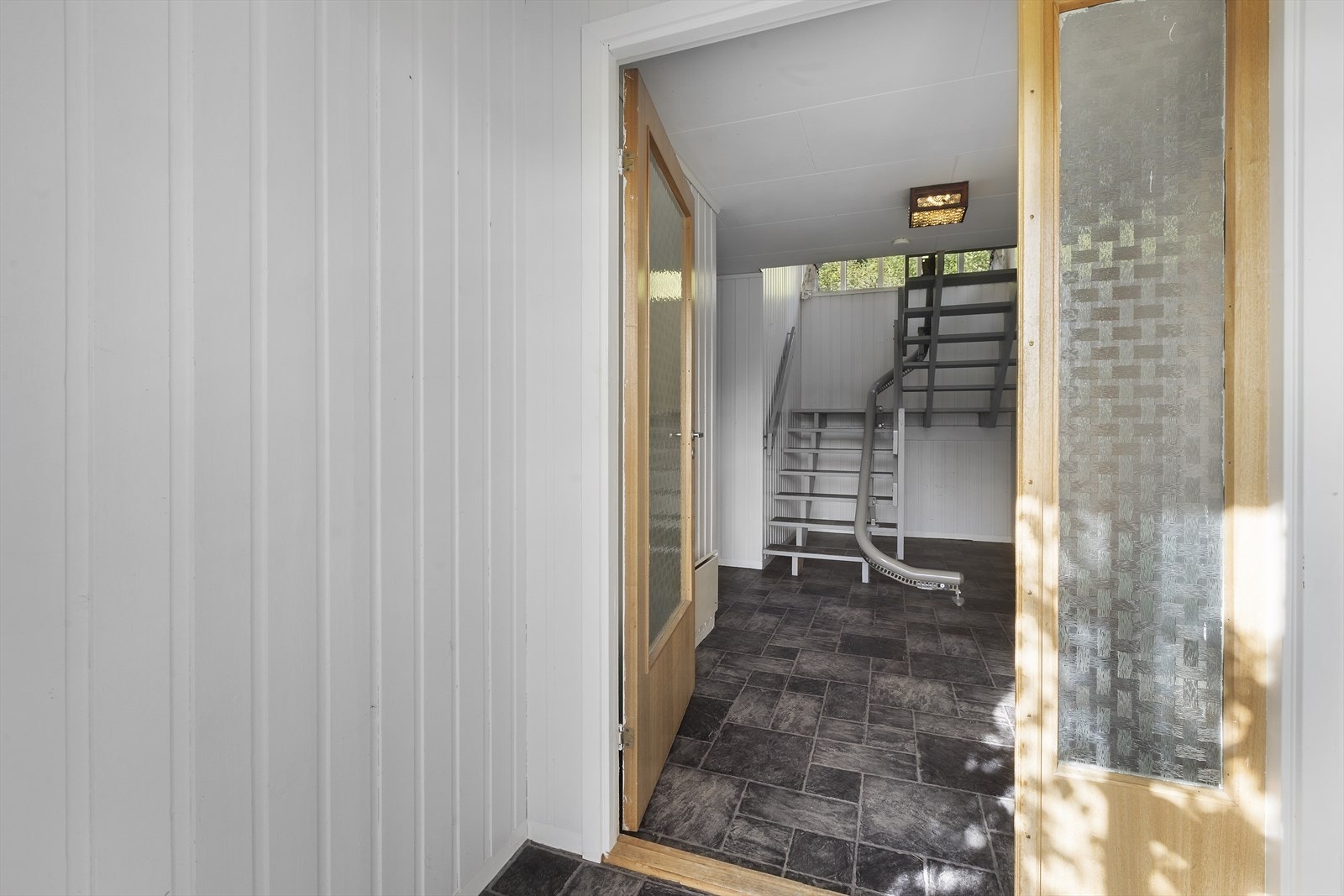 Romslig hall med trapp til hovedetasjen. Galleribilde