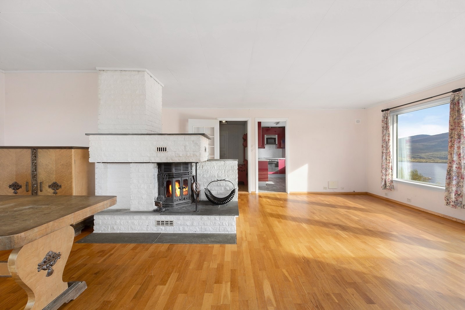 Rommet har L-form rundt peisovnen, og man har god plass til flere møbleringer. Galleribilde