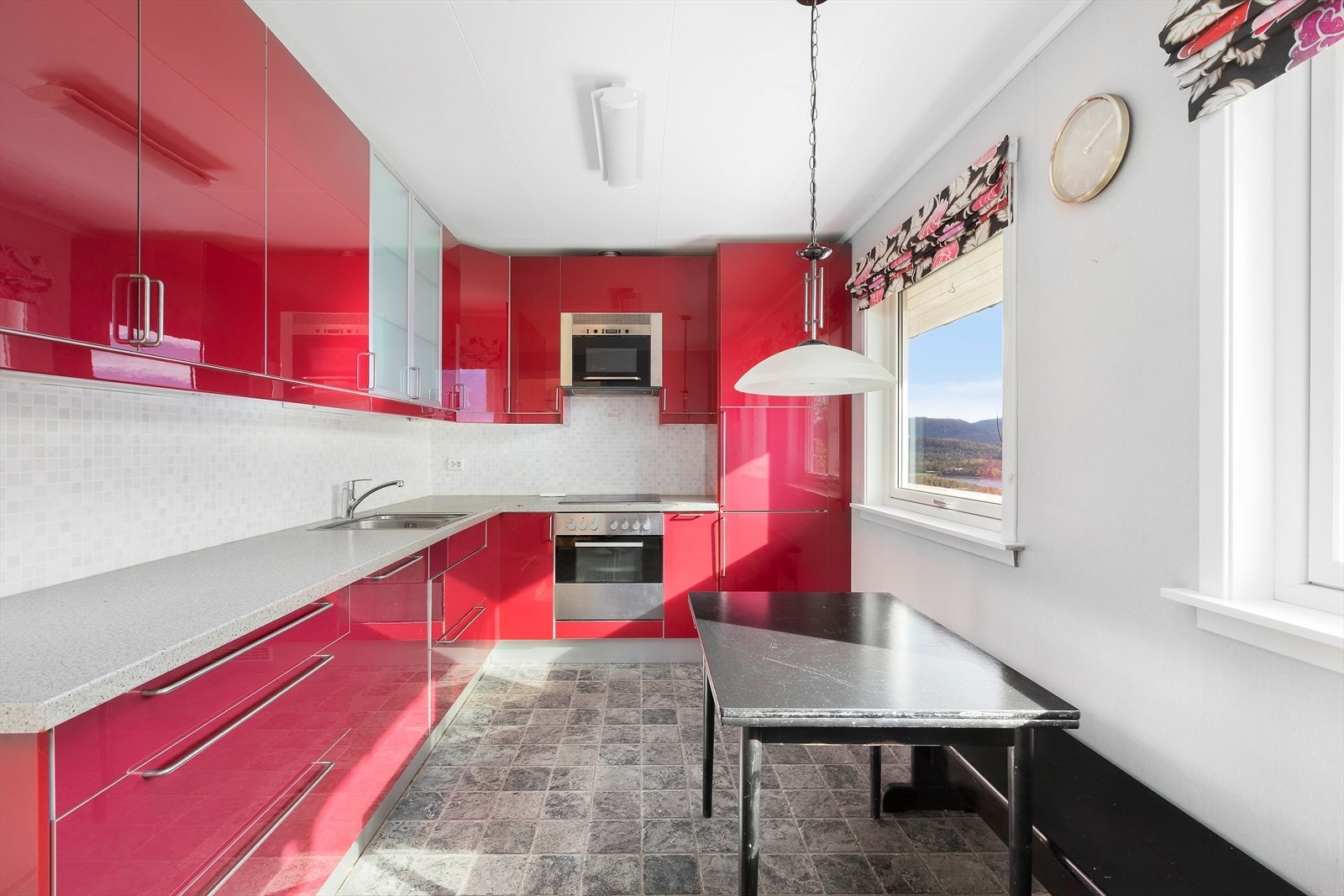 Sprek IKEA kjøkkeninnredning i røde, glatt fronter med laminat benkeplate og integrerte hvitevarer. Galleribilde