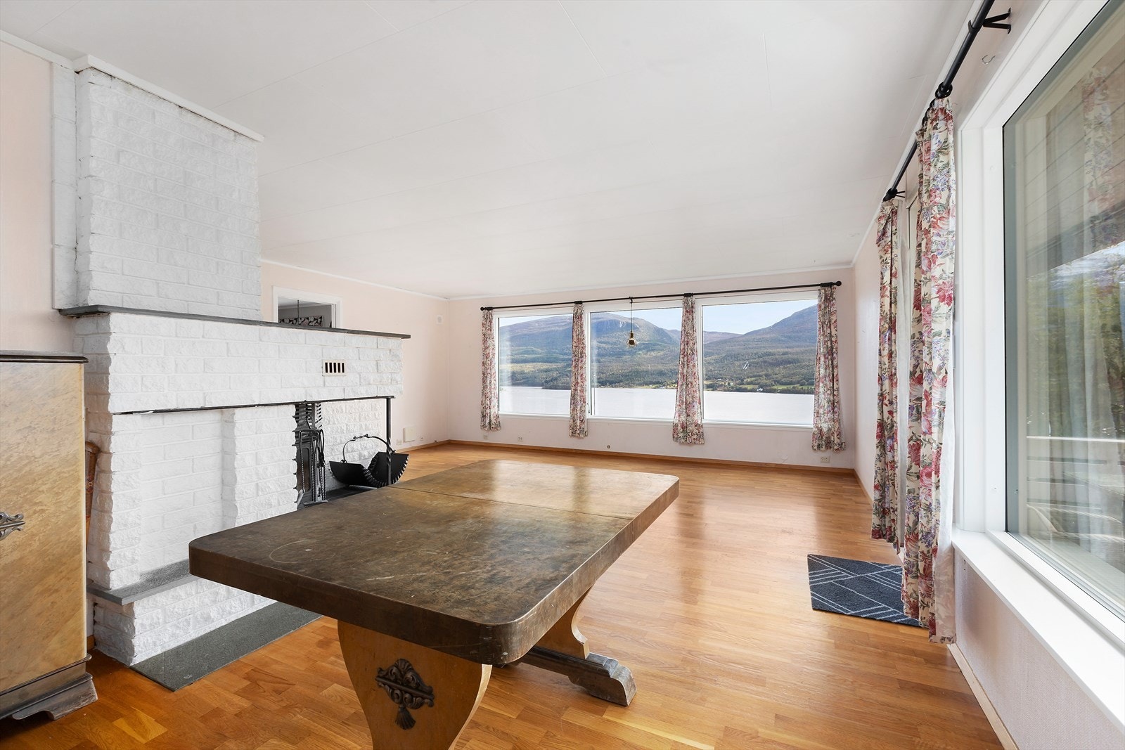 Romslig stue/ spisestue med store vinduer som slipper mye lys inn i rommet og gir kjempefin utsikt mot Fannefjorden, Snøfjellet og Skåla. Galleribilde