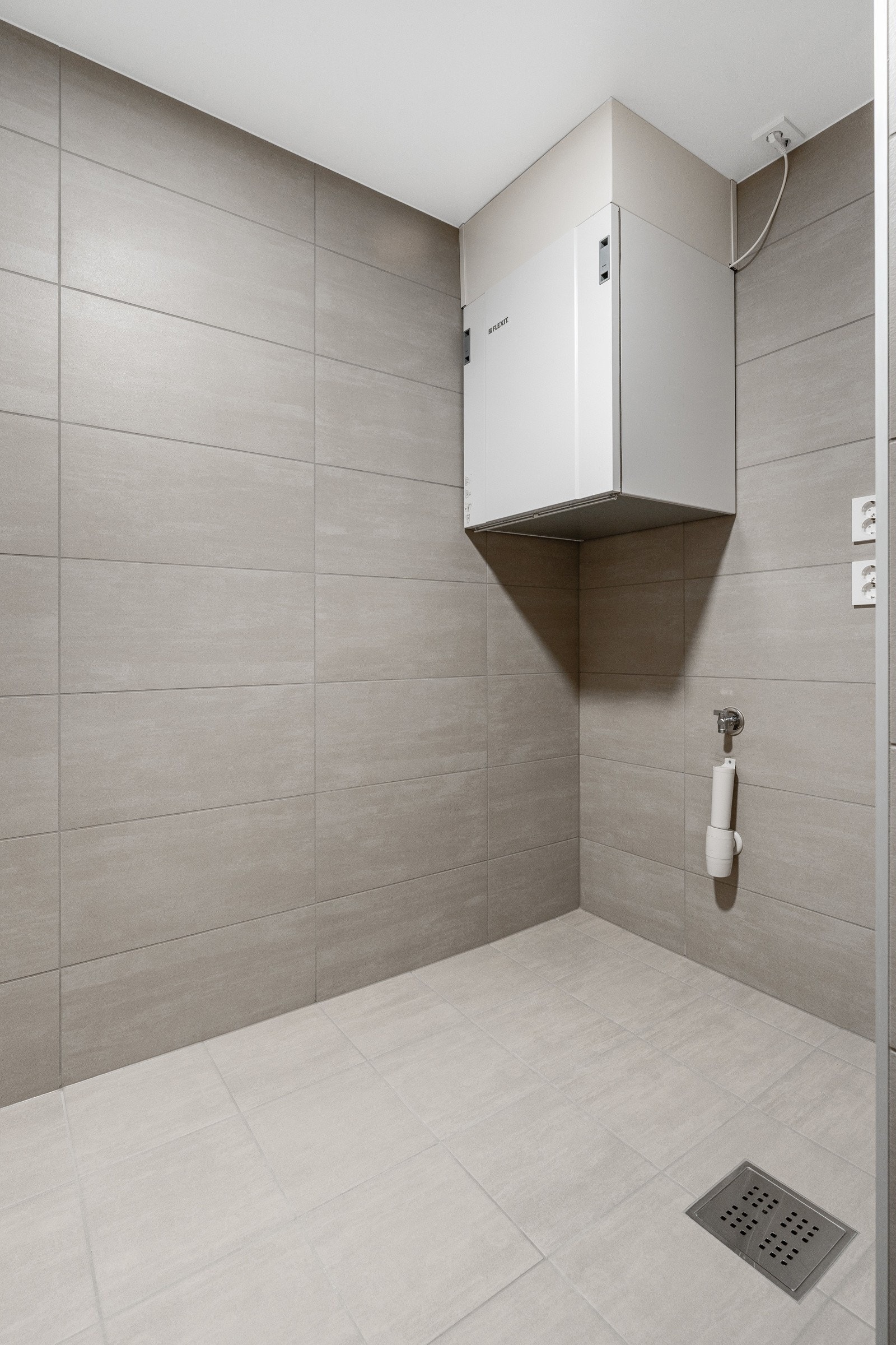 Leiligheten har et eget teknisk rom, flislagt og med opplegg for vaskemaskin. Galleribilde