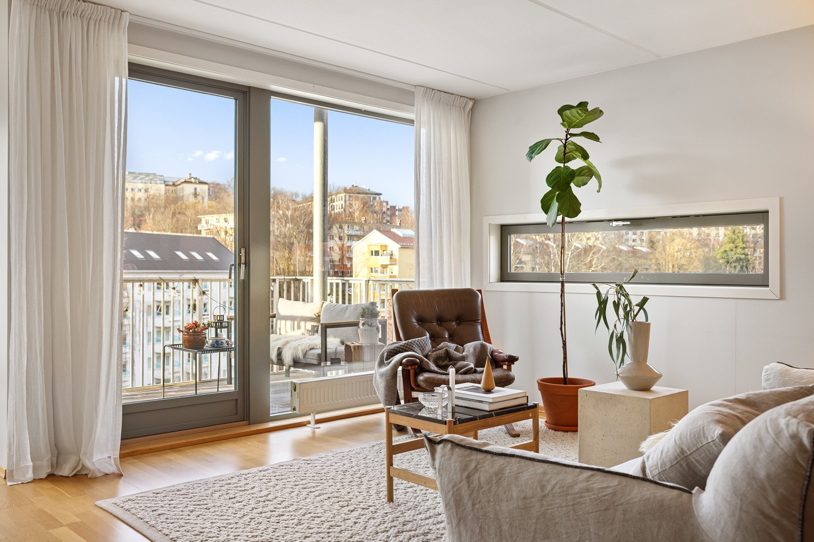 En lys og romslig stue med store vindusflater som rammer inn en nydelig utsikt Galleribilde