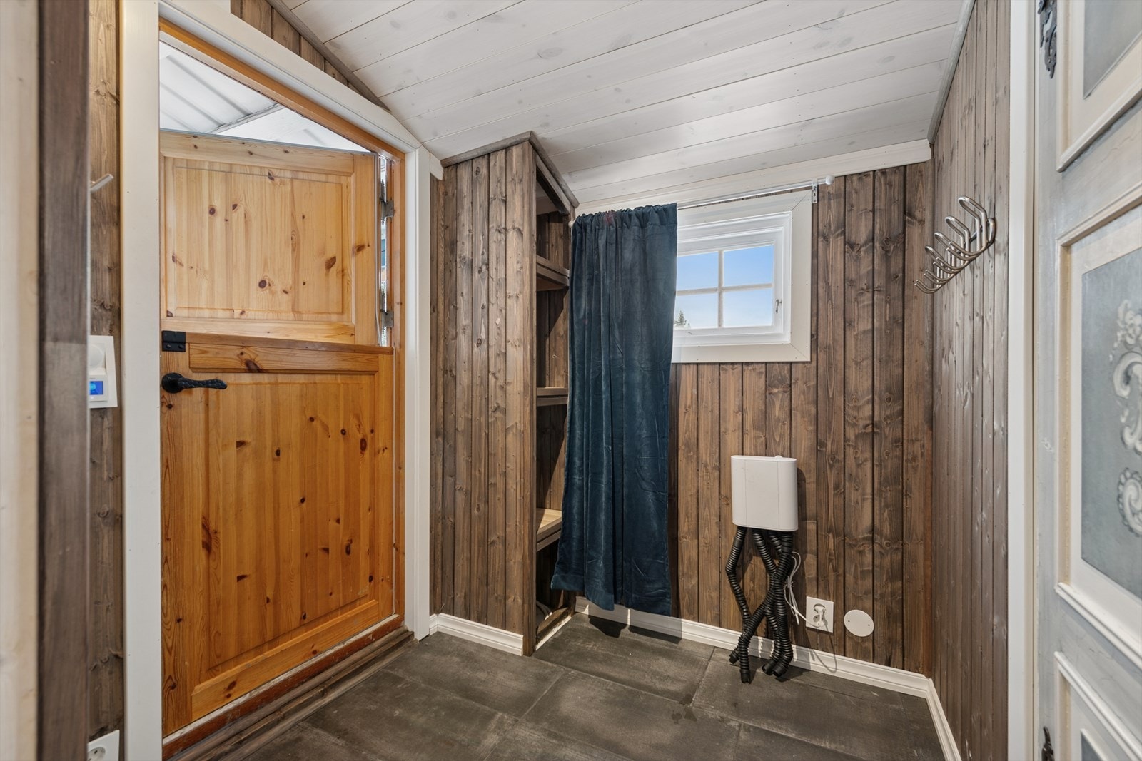 Entréen har flislagt gulv og beiset panel på veggene. Galleribilde