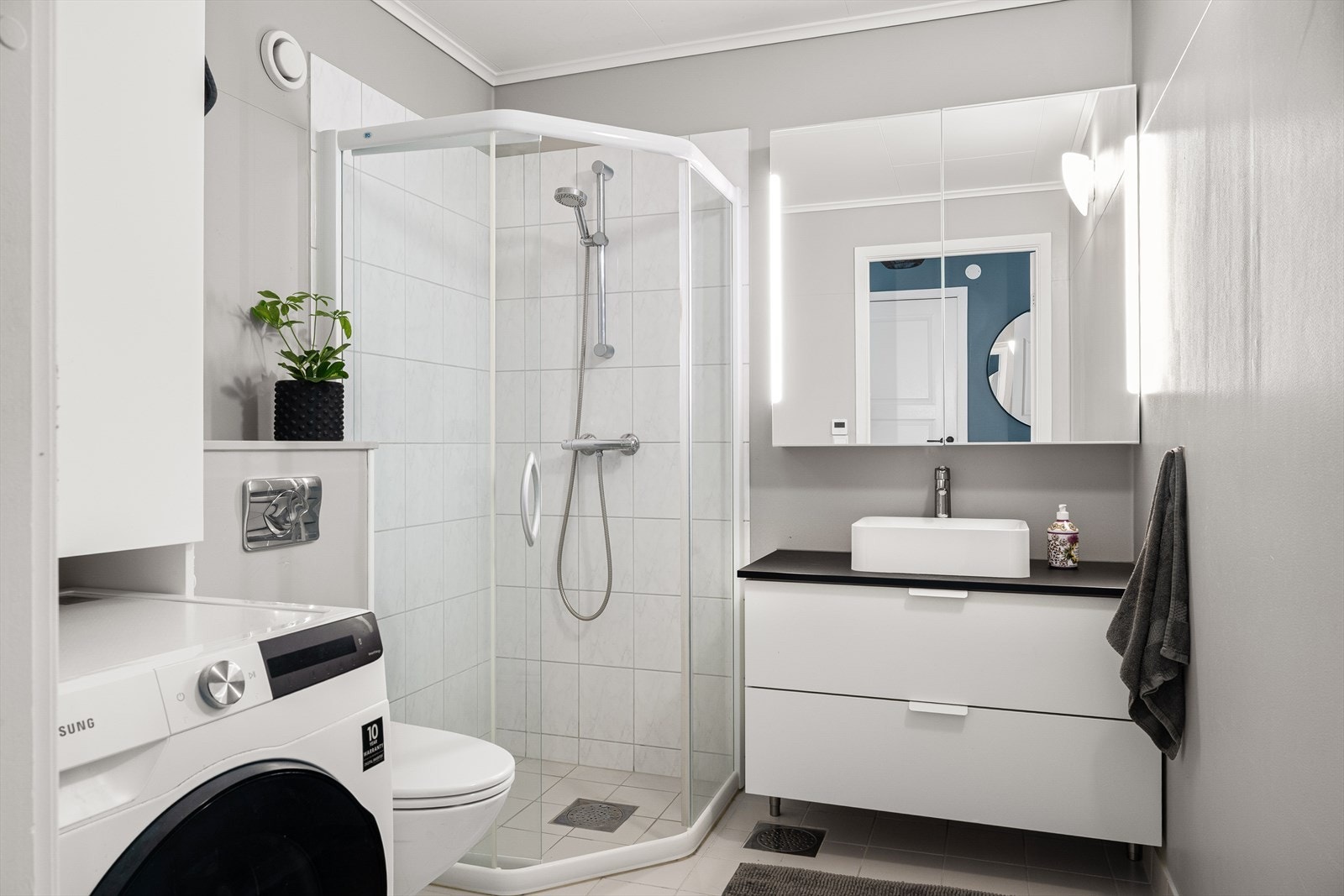 Baderommet har fliser på gulv med vannbåren gulvvarme og vegger med våtromsbelegg. Galleribilde