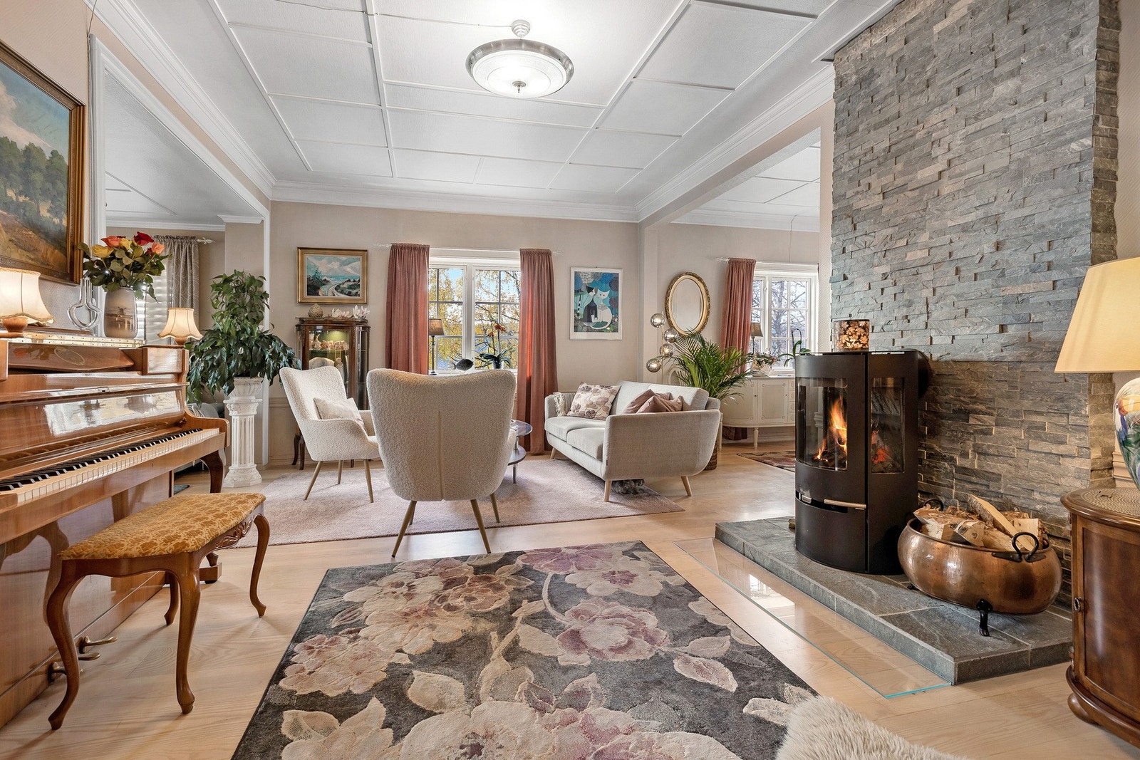 Lun og innbydende stue med peisovnog god plass til møblering. Lyse flater, store vinduer og klassiske detaljer skaper en varm og elegant atmosfære. Galleribilde