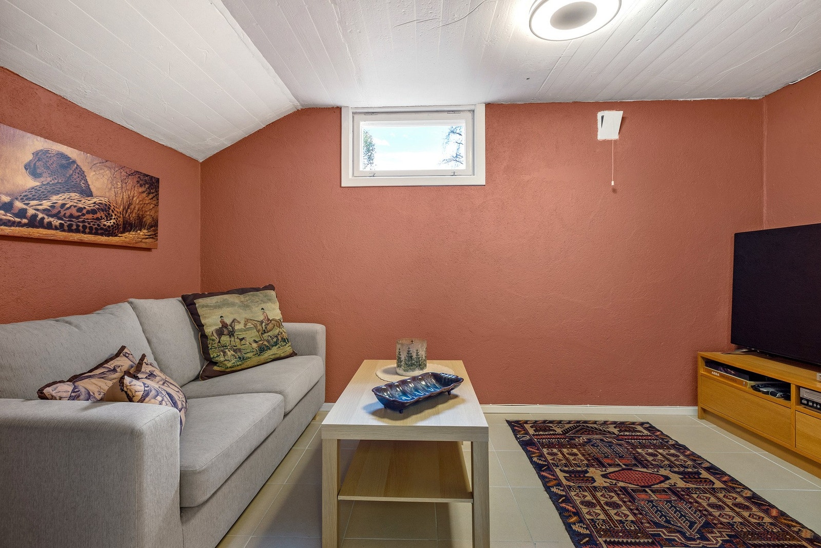 Innredet tv-rom med malt mur, lavt under taket og vindu som slipper inn dagslys - perfekt som TV- eller hobbyrom. Rommet er ikke omsøkt til dagens bruk/formål. Galleribilde