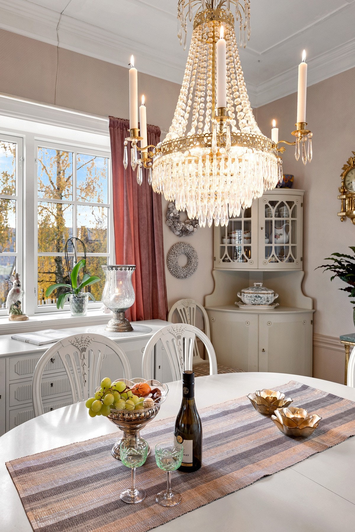 Stemningsfull spisestue med klassisk lysekrone, lyse farger og delikate møbler - perfekt for hyggelige måltider og selskap. Møblement medfølger ikke i handelen. Galleribilde