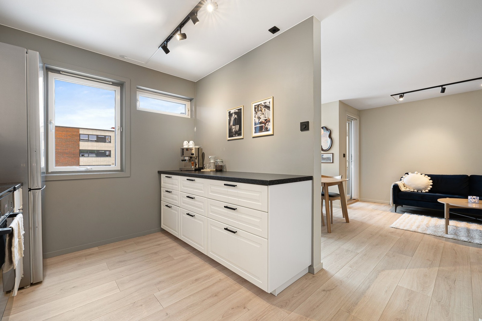 Den ekstra benkeflaten langs motsatt vegg gir praktiske arbeidssoner og gjør rommet svært funksjonelt. Galleribilde