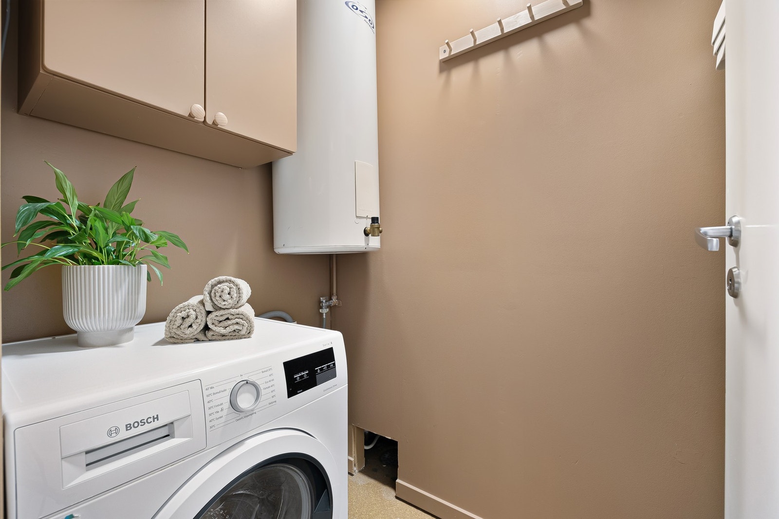 I tillegg til separat bad og toalettrom finner du et eget vaskerom. Rommet er på 1,9 kvm og har naturligvis kran og avløp for vaskemaskin og du finner også leilighetens varmtvannstank her. Galleribilde