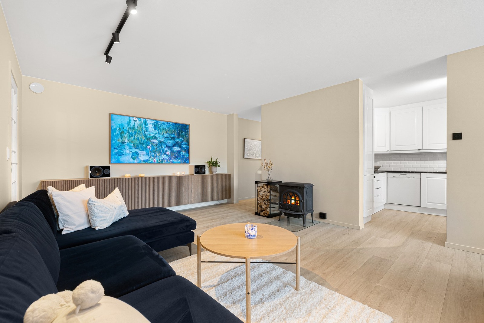 Stua ble renovert i 2023 og har et lekkert uttrykk med beige-fargetoner på vegg og sorte detaljer på stikkontakter, lysbrytere og spotskinne. I forbindelse med renoveringen ble det monterte godkjent glassplate under ildstedet. Galleribilde