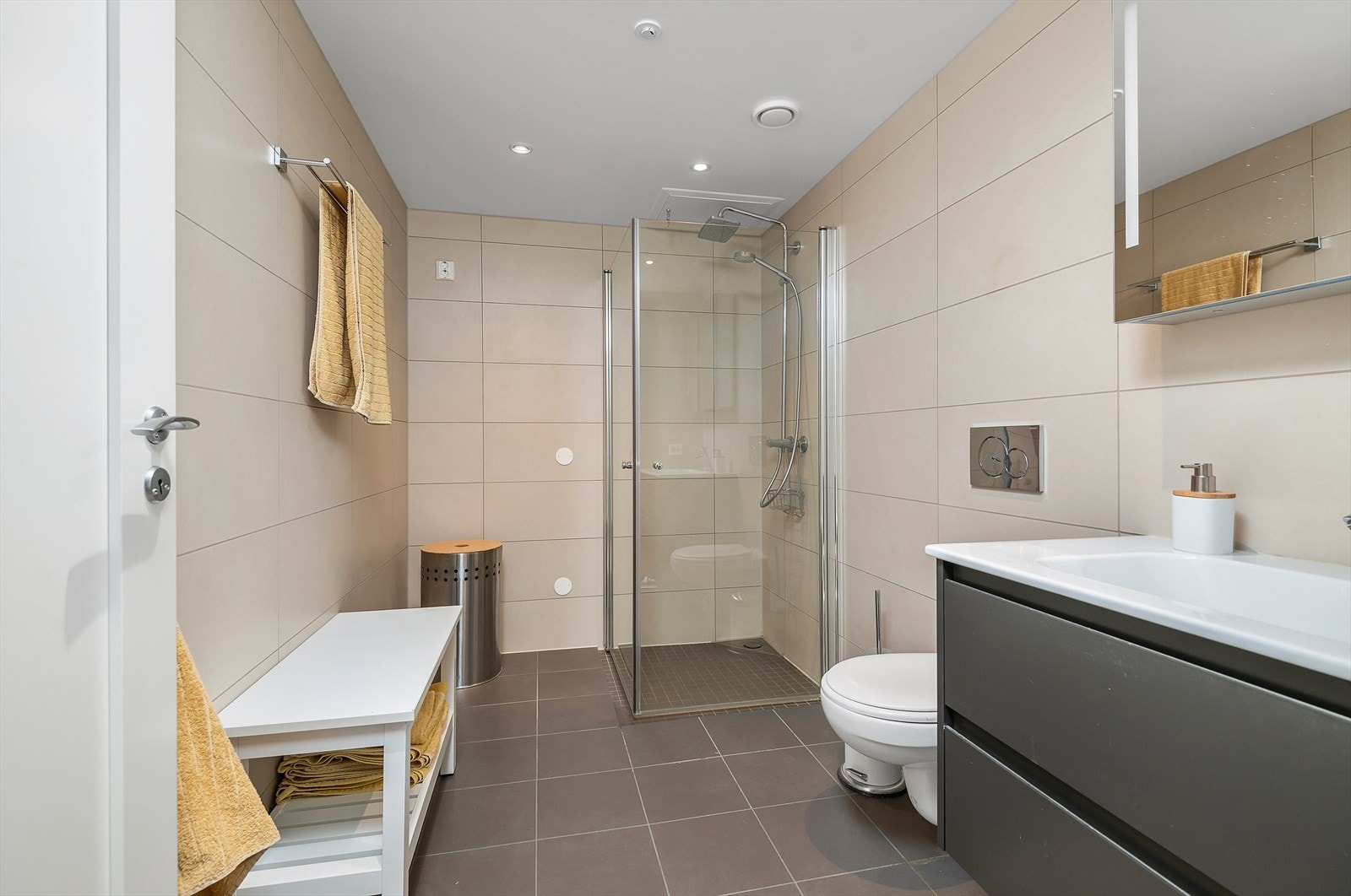 Det andre badet har direkte tilgang fra hovedsoverommet. Dette badet er utstyrt med en moderne innredning med ovenpåliggende servant, speilskap med belysning, toalett og dusjhjørne med glassvegger og regnfallsdusj. Galleribilde